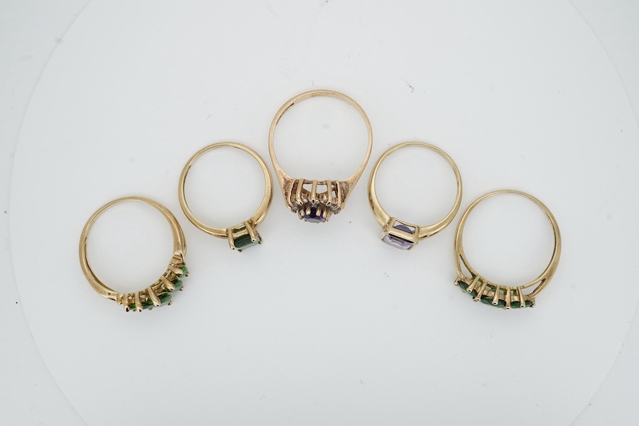 Five gem-set rings, comprising: three rings set with peridots and, one ring set with an amethyst, and one designed as a cluster of amethyst and rock crystal, each mounted in 9ct gold, sizes N-U, each with British hallmar